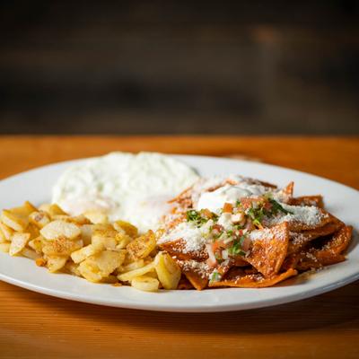 Fried tortilla chips simmered in red salsa, sour cream and country potatoes on the side.
