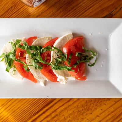 Caprese salad, wit sliced tomatoes and cheese, and basil