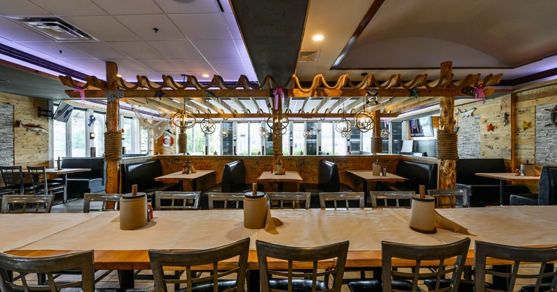 Interior - a long wooden table, metal chairs, black leather booths, decorative wooden beams