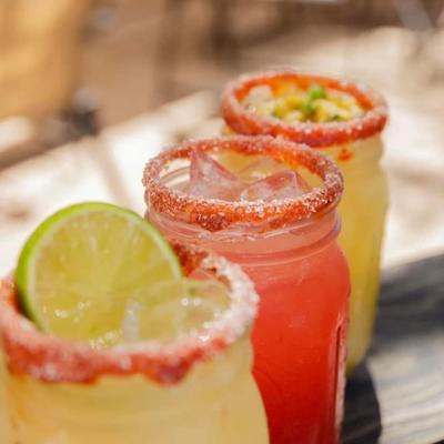 Three margaritas with salted rims and lime garnishes.