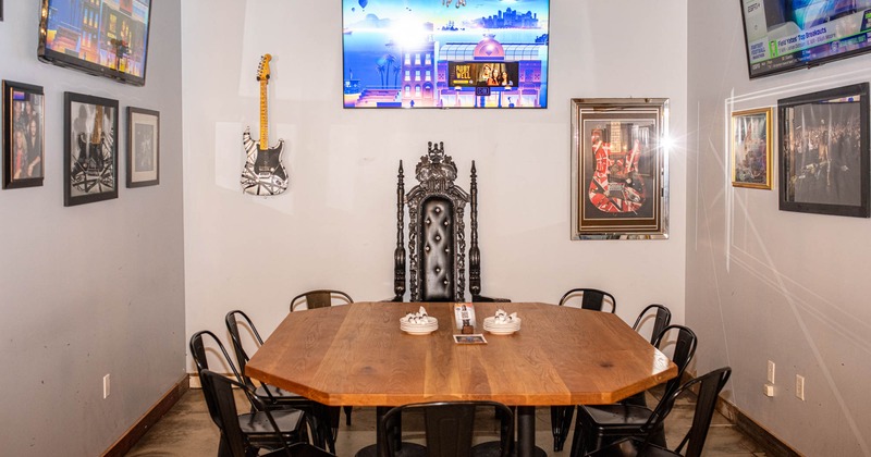 Prominent table for ten people, huge TV screens and pictures on the walls