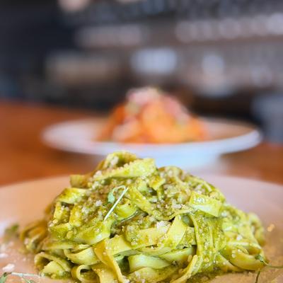 A plate of tagliatelle pasta with pesto sauce.