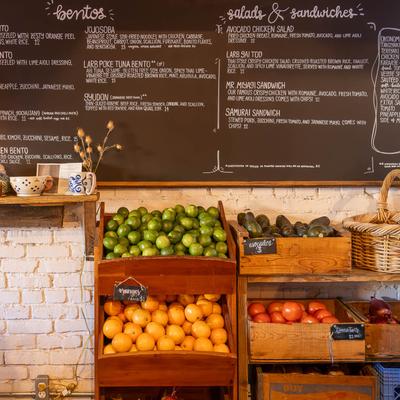Produce for sale with a chalkboard menu above.