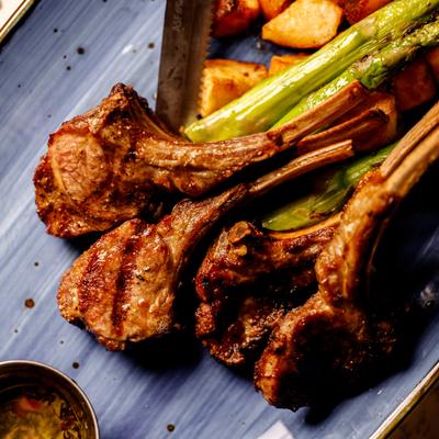 Grilled lamb chops served with baked potatoes and asparagus.