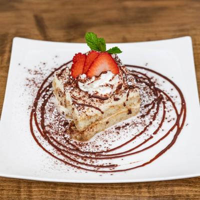 Tiramasu served and topped with strawberries.