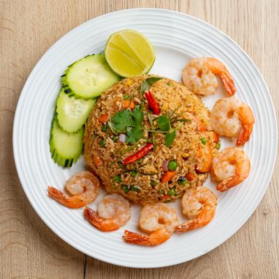 Garlic Shrimp Fried Rice garnished with cucamber slices and a lime wedge.