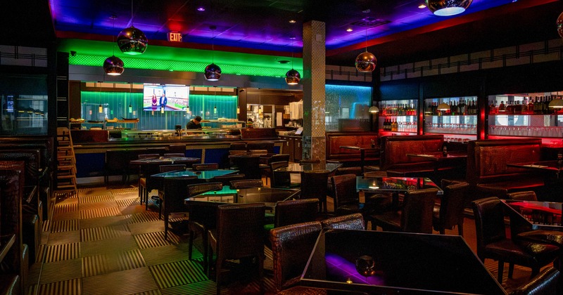 Interior, glass tables, leather chairs, and red-lit booths