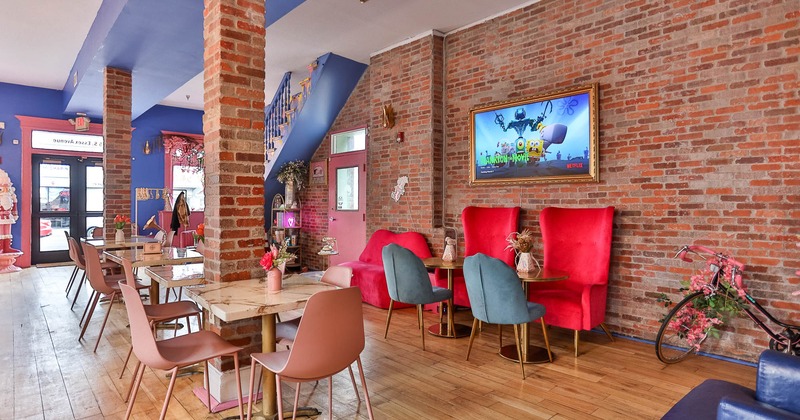 Interior, dining area, marble top tables with chairs, red brick walls, restaurant entrance