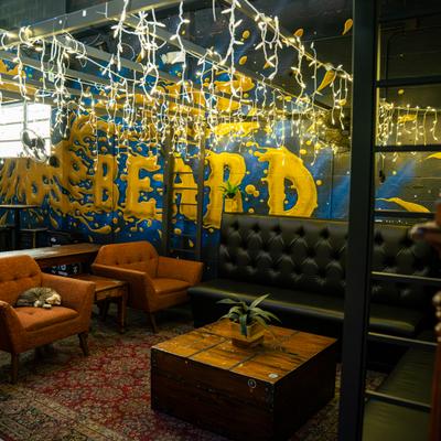 Private lounge seating with string lights and grafiti-style mural.