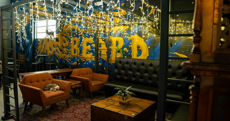Private lounge seating with black sofas and murals on the wall