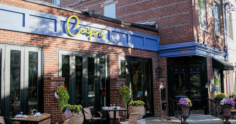 Exterior, front view to restaurant, tables and chairs, entrance, sign above