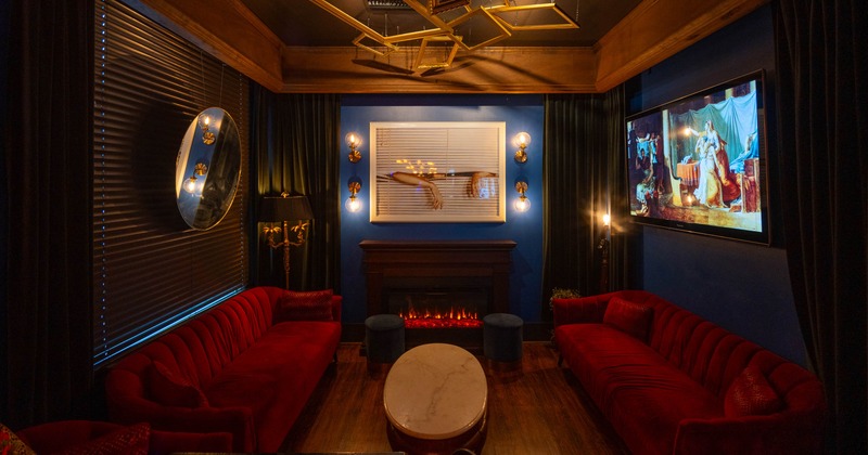 A cozy room with red velvet sofas and a marble table