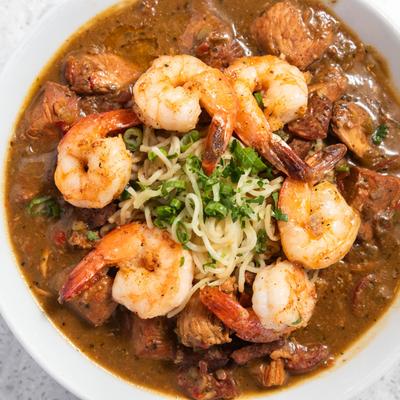 Gumbo ramen with shrimp, chicken, sausage, noodles, and scallions.