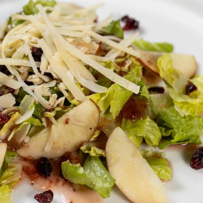 Salad with lettuce, apples, raisins, cheese, and nuts.
