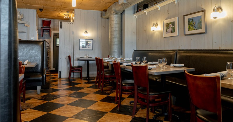 Interior, seating area with tables, chairs and leather banquette