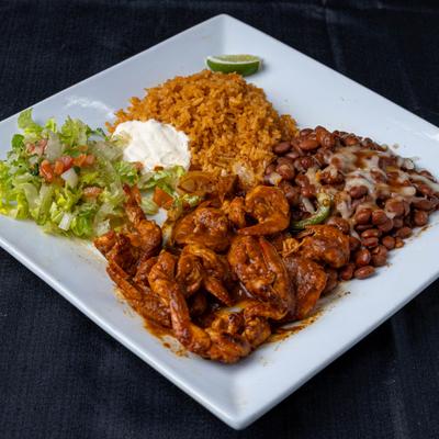 Shrimp in a spicy sauce served with rice, beans, and fresh salad.