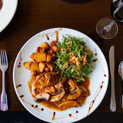 Chicken with sauce, mushrooms, roasted potatoes and arugula salad.