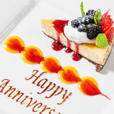 Cheesecake, topped with berries, fruit sauce, whipped cream and mint  garnish