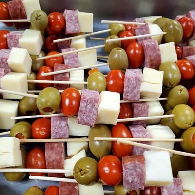 Antipasto skewers featuring olives, cherry tomatoes, salami, and cubed cheese.