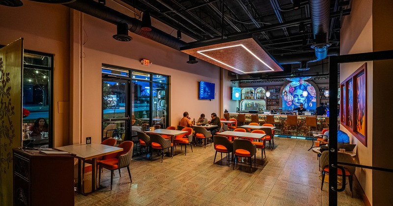 Modern restaurant dining area with bar and colorful decor