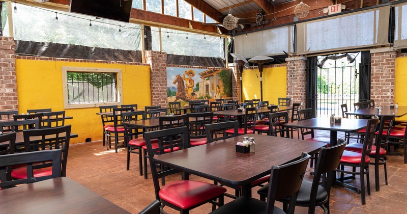 Exterior, covered patio, tables and chairs, TV on the wall, patio entrance