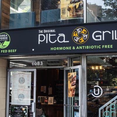 Pita Grill restaurant entrance with signage promoting hormone and antibiotic free food.