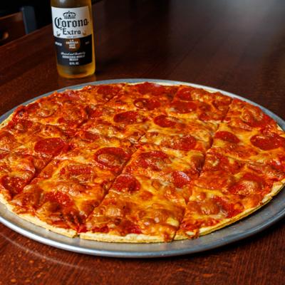 Pepperoni pizza, accompanied by a bottle of beer.