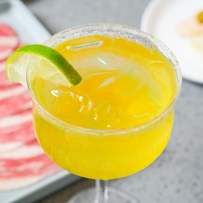 Margarita served in a stemmed cocktail glass, garnished with a lime wedge.