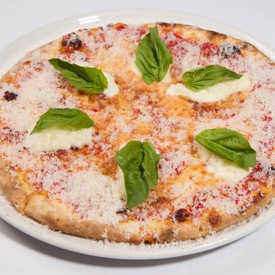 Margherita pizza with grated cheese and basil garnish.