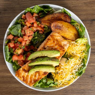 Grilled salmon bowl with shredded cheese, avocado, tomato salsa, and plantains.