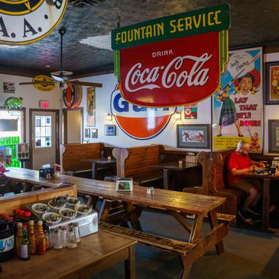 Interior with wooden booths, vintage decor, and a long picnic table.