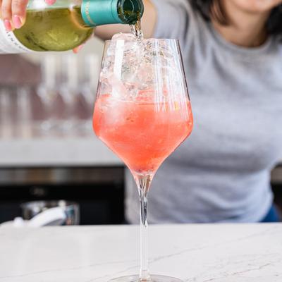 Bartender is making a spritz cocktail.