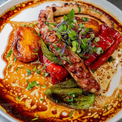 Charred octopus with roasted bell peppers.