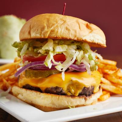 Cheeseburger, with lettuce, pickles, tomato, red onion, and fries.
