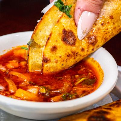 Crispy quesabirria taco dipped into savory, rich beef consommé broth.