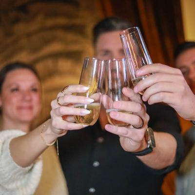 Interior, three individuals raising champagne glasses in a toast