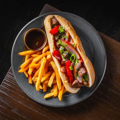 Beef tenderloin sandwich with onions, tomatoes, cilantro, and fries.
