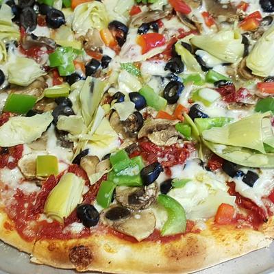 Vegetarian Pizza, with mushrooms, artichokes, bell pepper, tomatoes, olives, and red sauce.