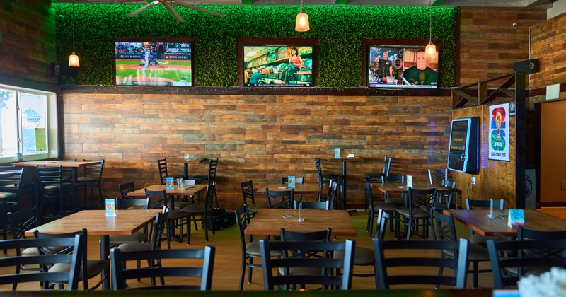 Interior, seating area with a few TVs mounted on the wall