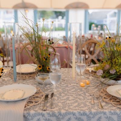 Table set up with plates, glasses and arrangements of branches and foliage.