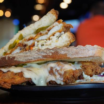 Fried chicken sandwich layered with cheese and pickles.