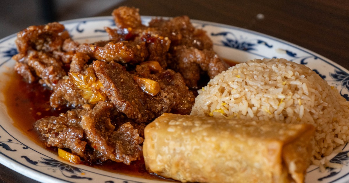 Orange Beef served with rice and a spring roll on the side