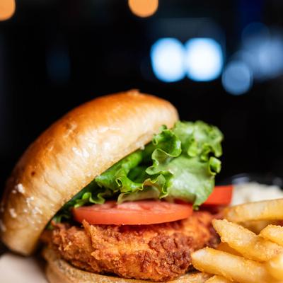 Deep fried chicken sandwich, with lettuce, tomato, and fries.