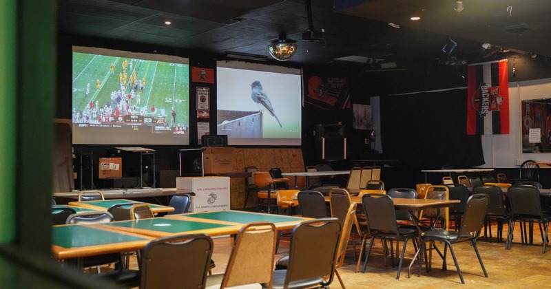 Diner area, tables, chairs, screens above