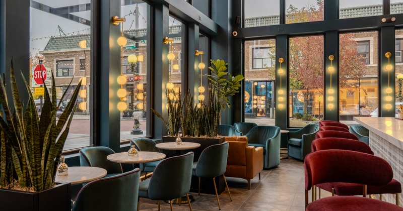 Interior seating area with round tables and velvet seating