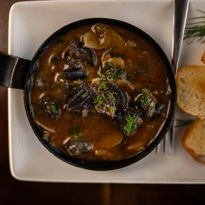Escargots skillet with toasted bread on the side, overhead view.