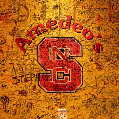Interior, a scribbled wall with North Carolina State Wolfpack logo.
