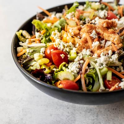 Chicken, cheese, greens and vegetables salad bowl