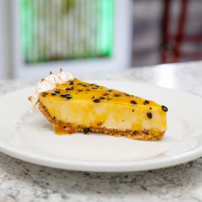 Passion fruit cheesecake slice on a white plate.