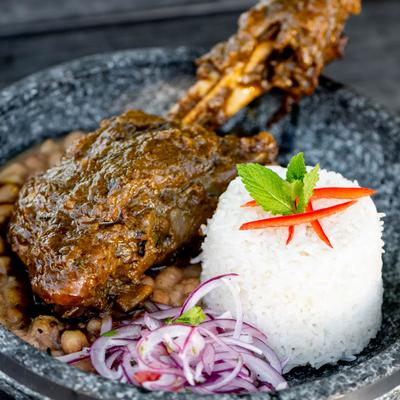 Peruvian lamb stew with a leg of lamb, rice and red onion